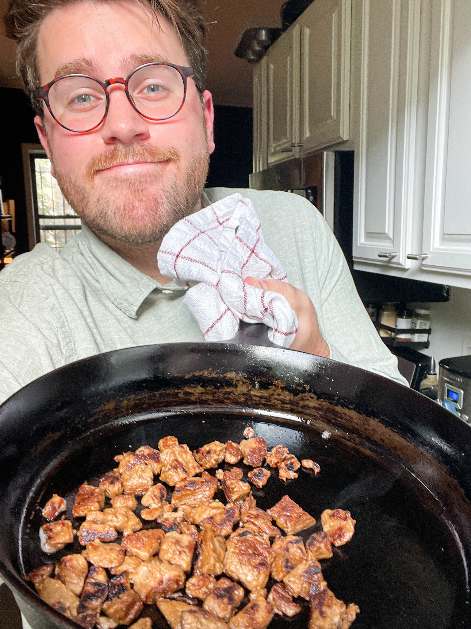 author holding up skillet in his kitchen