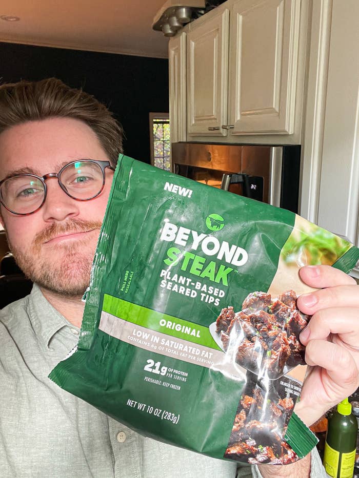 author holding up bag of beyond steak in his kitchen