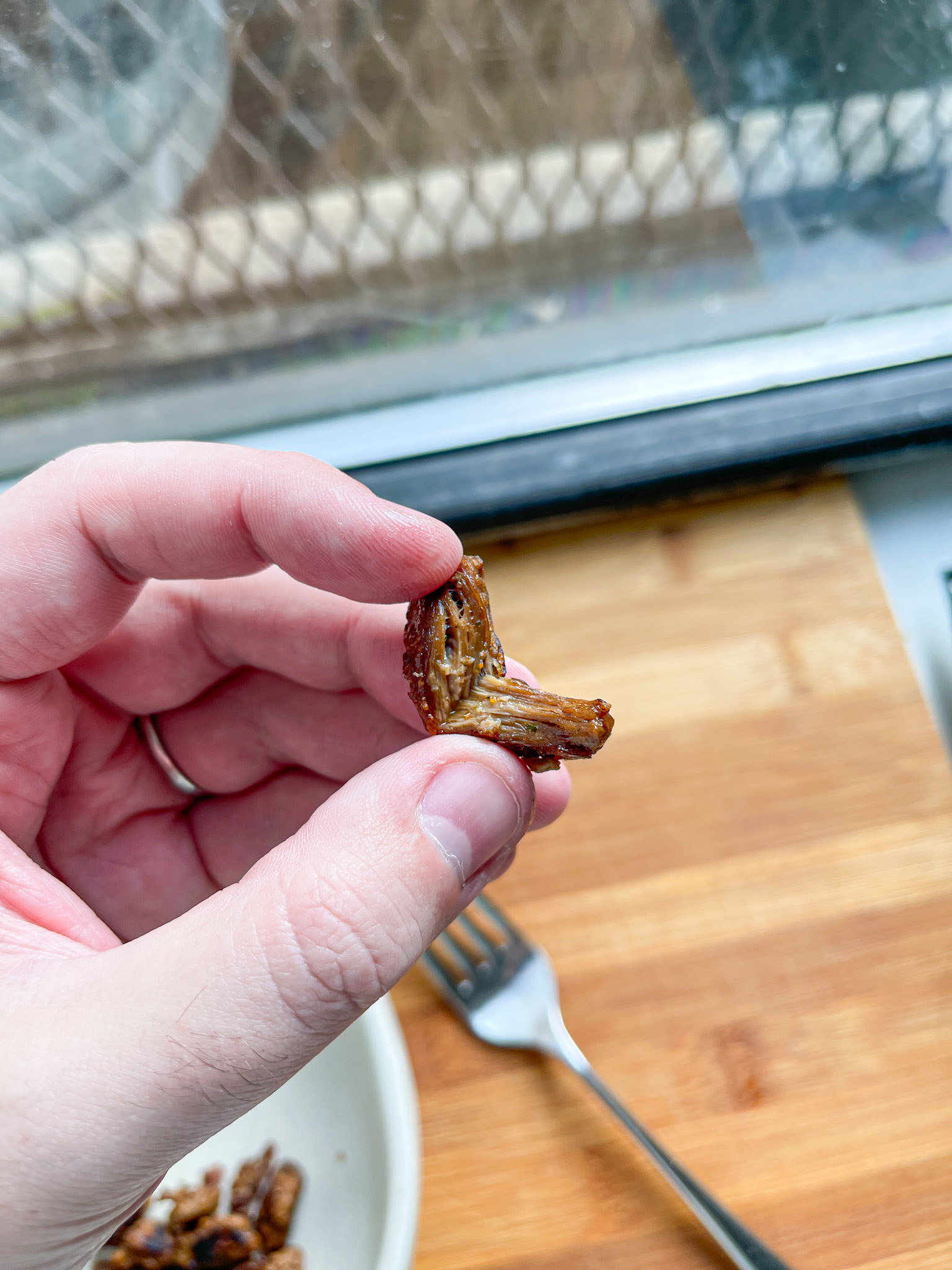 holding the beyond steak to show the shred like texture n the inside