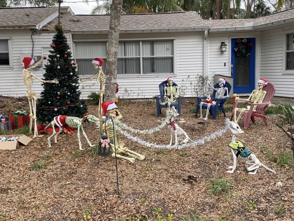 skeletons in santa hats lounging in the front yard