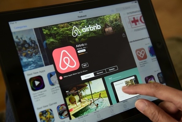 fingers using the airbnb app on a tablet