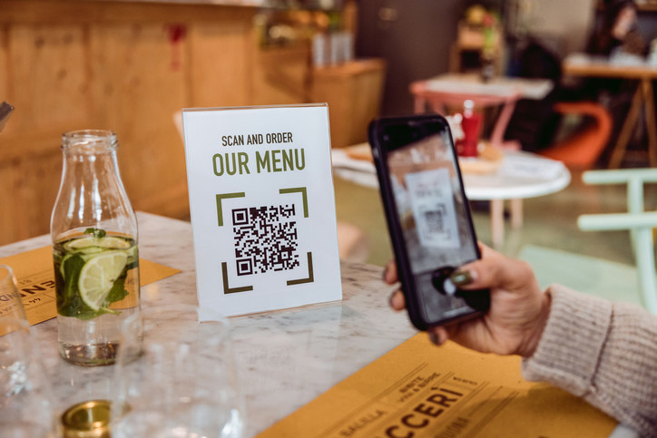 hand using a phone to scan the menu