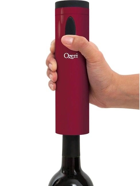 Someone using the wine bottle opener to open a bottle of wine