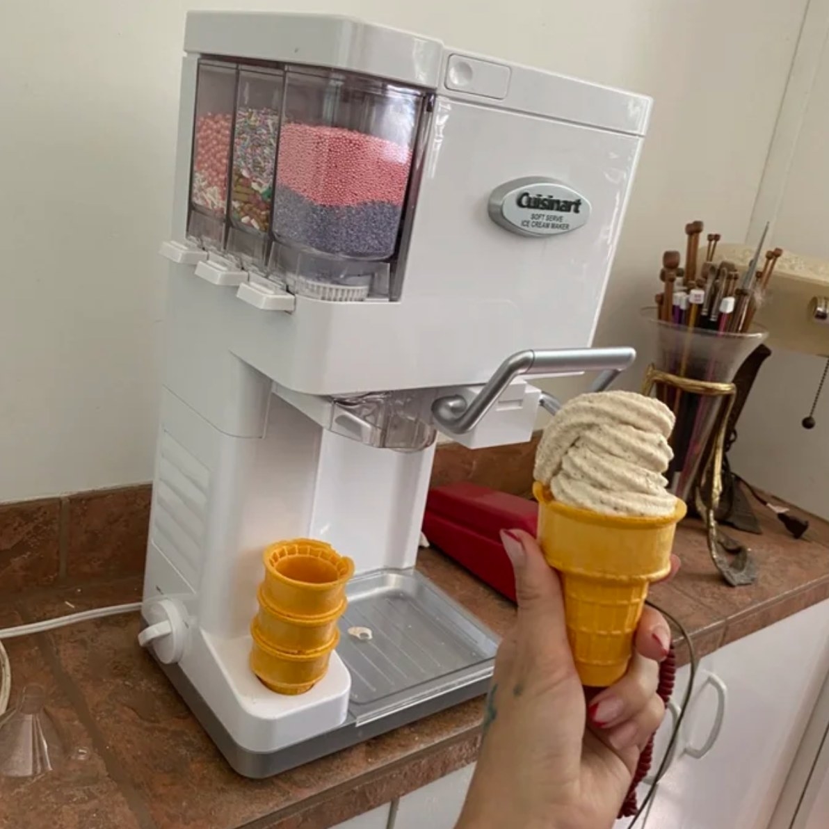 a reviewer&#x27;s photo of their ice cream maker and the soft serve cone they just made