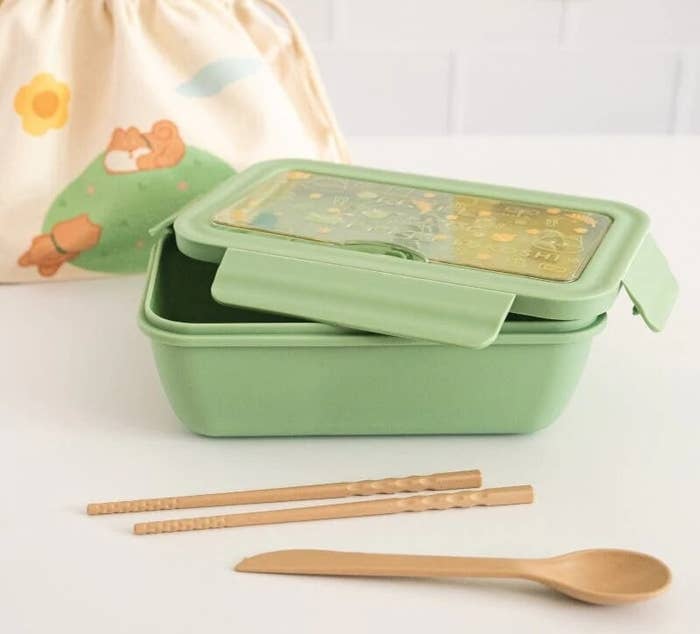 the bento box open and wooden utensils beside it