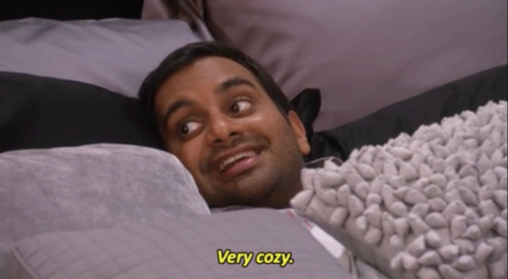 a man laying under pillows saying, &quot;very cozy&quot;