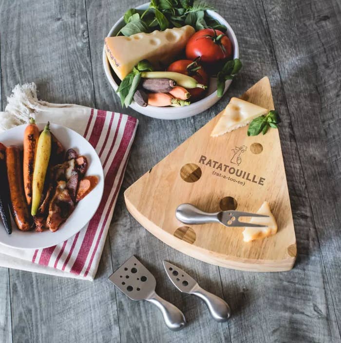the cheese board on a table surrounded by cheese and veggies