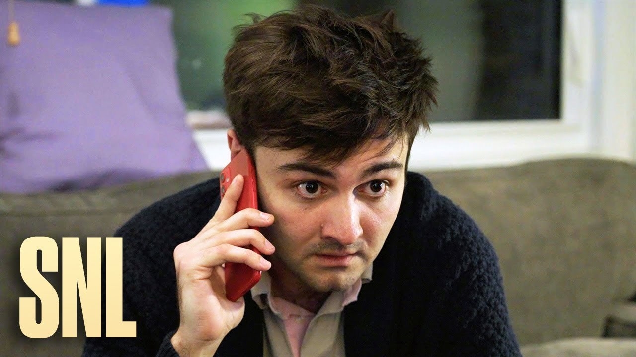 Close-up of John holding a phone to his ear