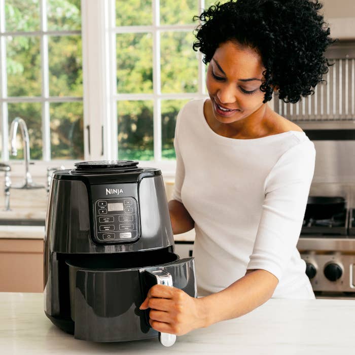 a model opening the air fryer