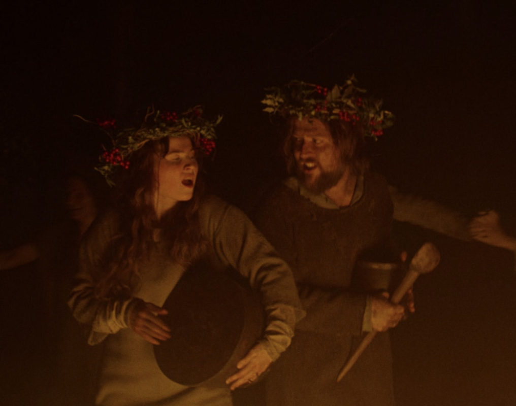 Ísadóra as a Viking wearing a wreath-type crown and beating a drum with Jonas Lorentzen