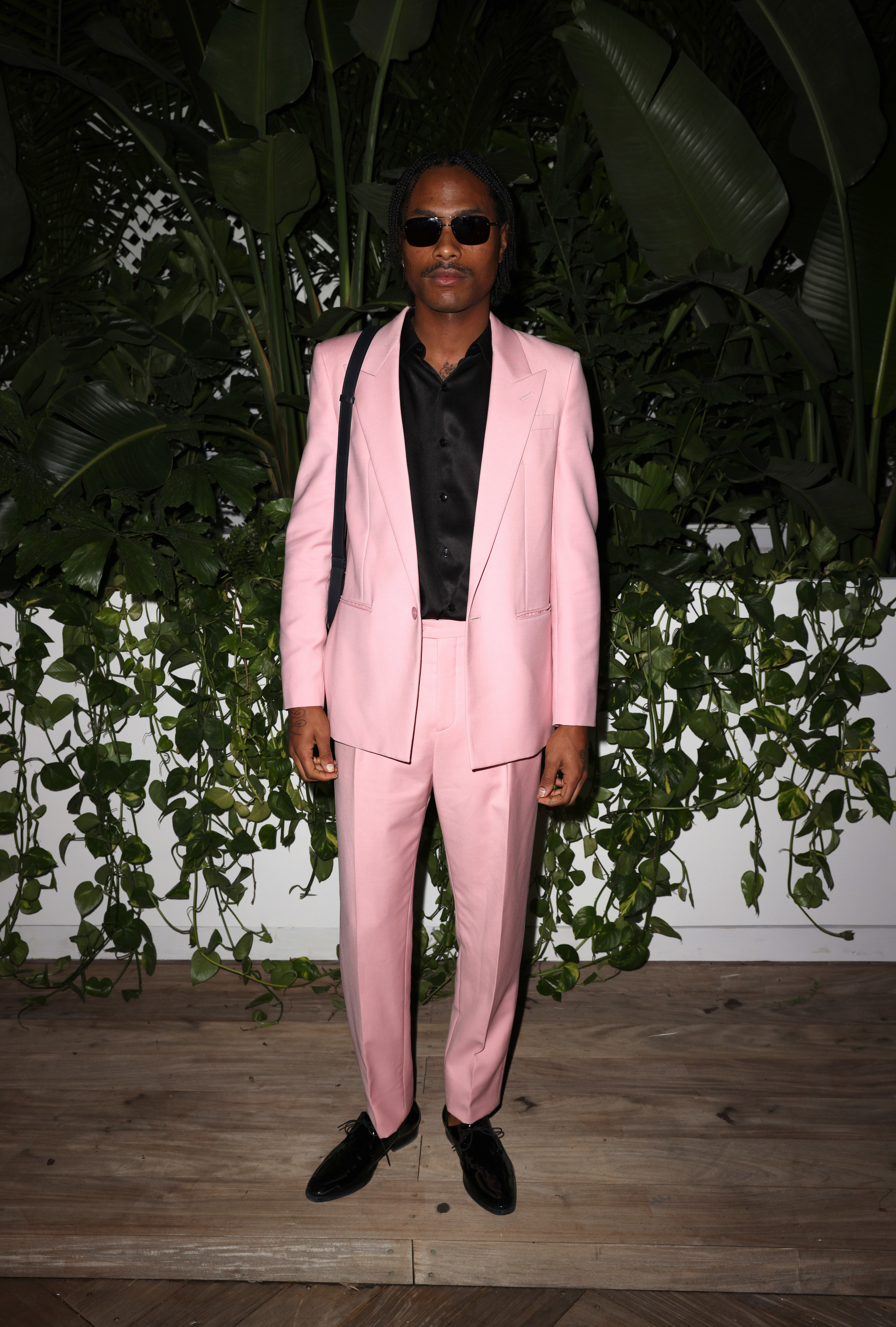 Steve, wearing a suit and sunglasses, poses for a photographer at an event