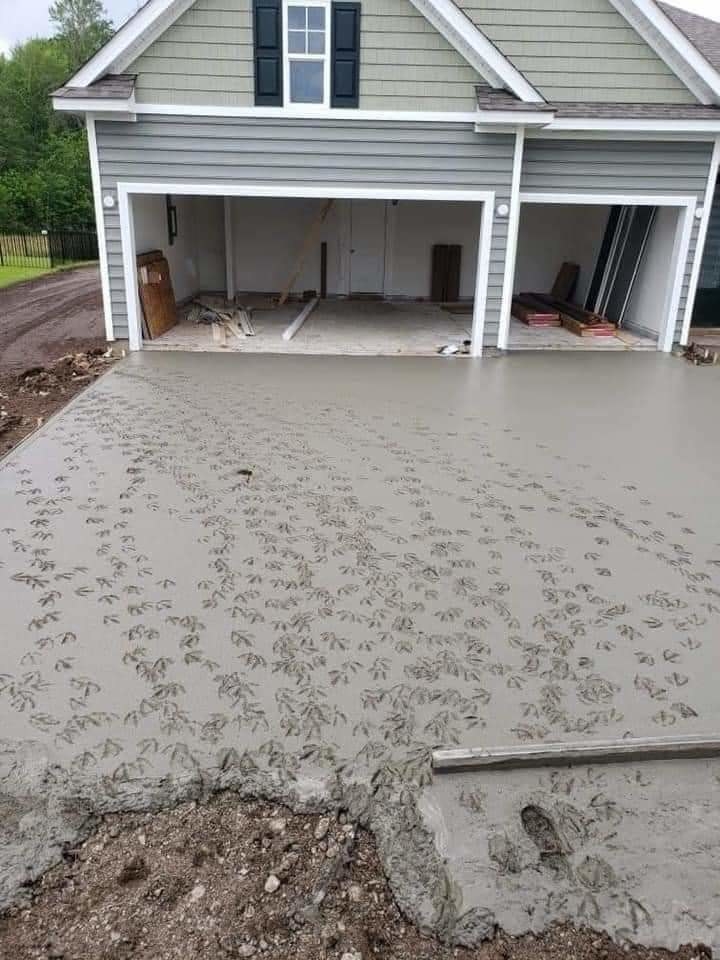 Many, many duck footprints on fresh cement outside a home&#x27;s garage