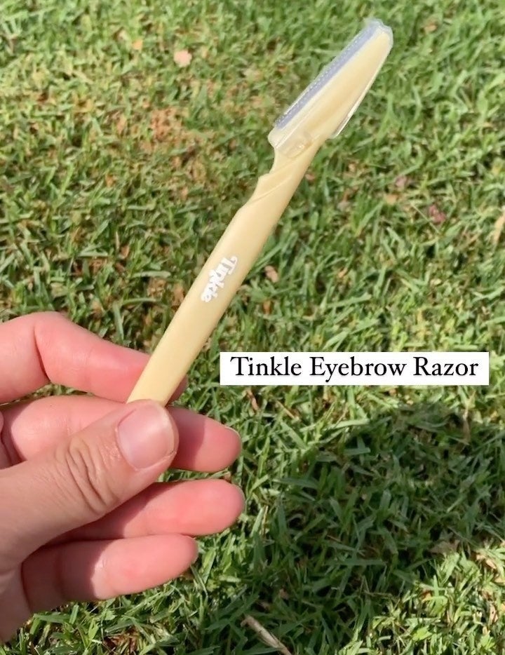 A person holding up a brow razor