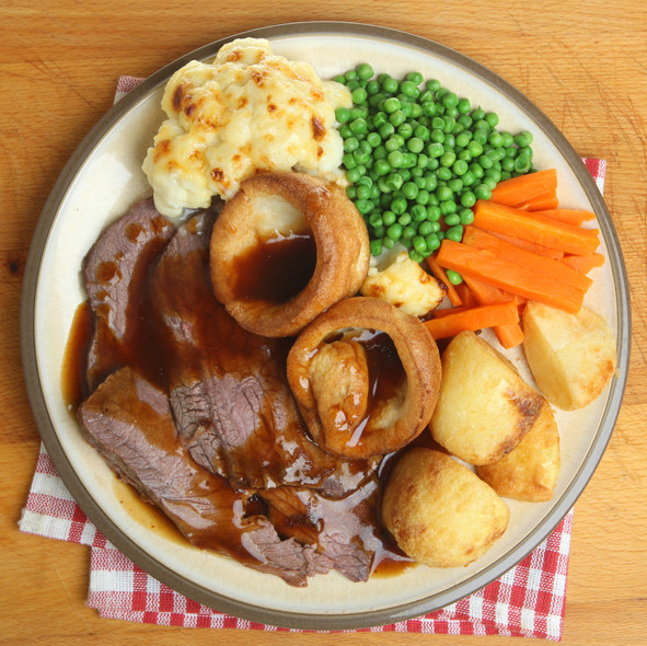 plate full of meat, potatoes, peas, carrots