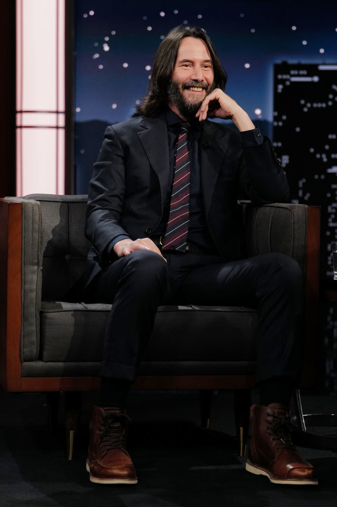 Keanu Reeves sitting during a late-night TV show interview