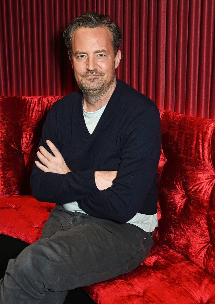 Matthew Perry sitting with his arms crossed