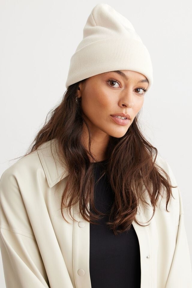 model wearing the beanie and a matching coloured jacket