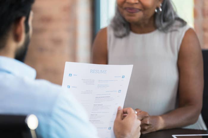 a person reads a resume during a job interview with a potential employee