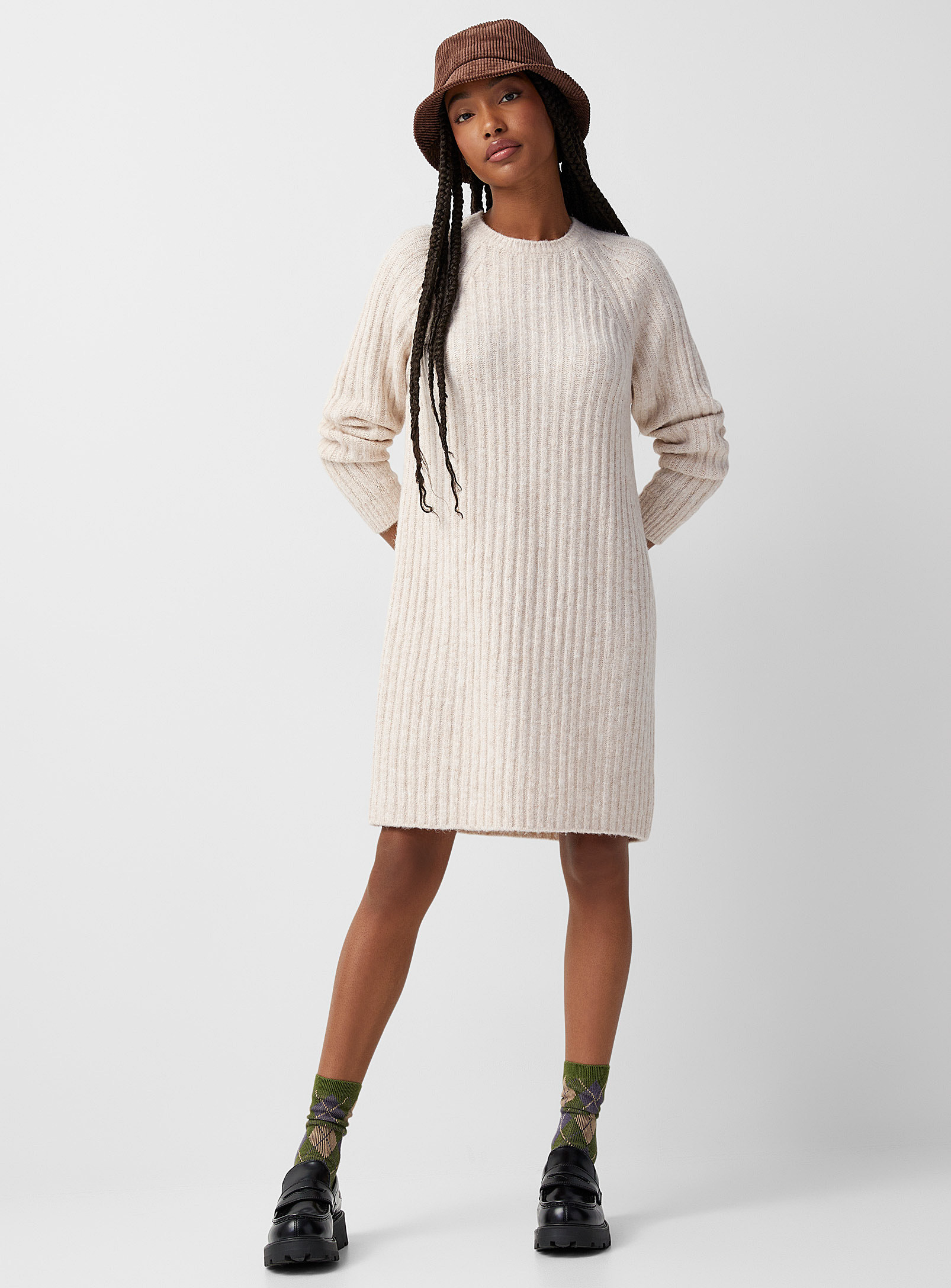 a person wearing the sweater dress with loafers and a corduroy bucket hat