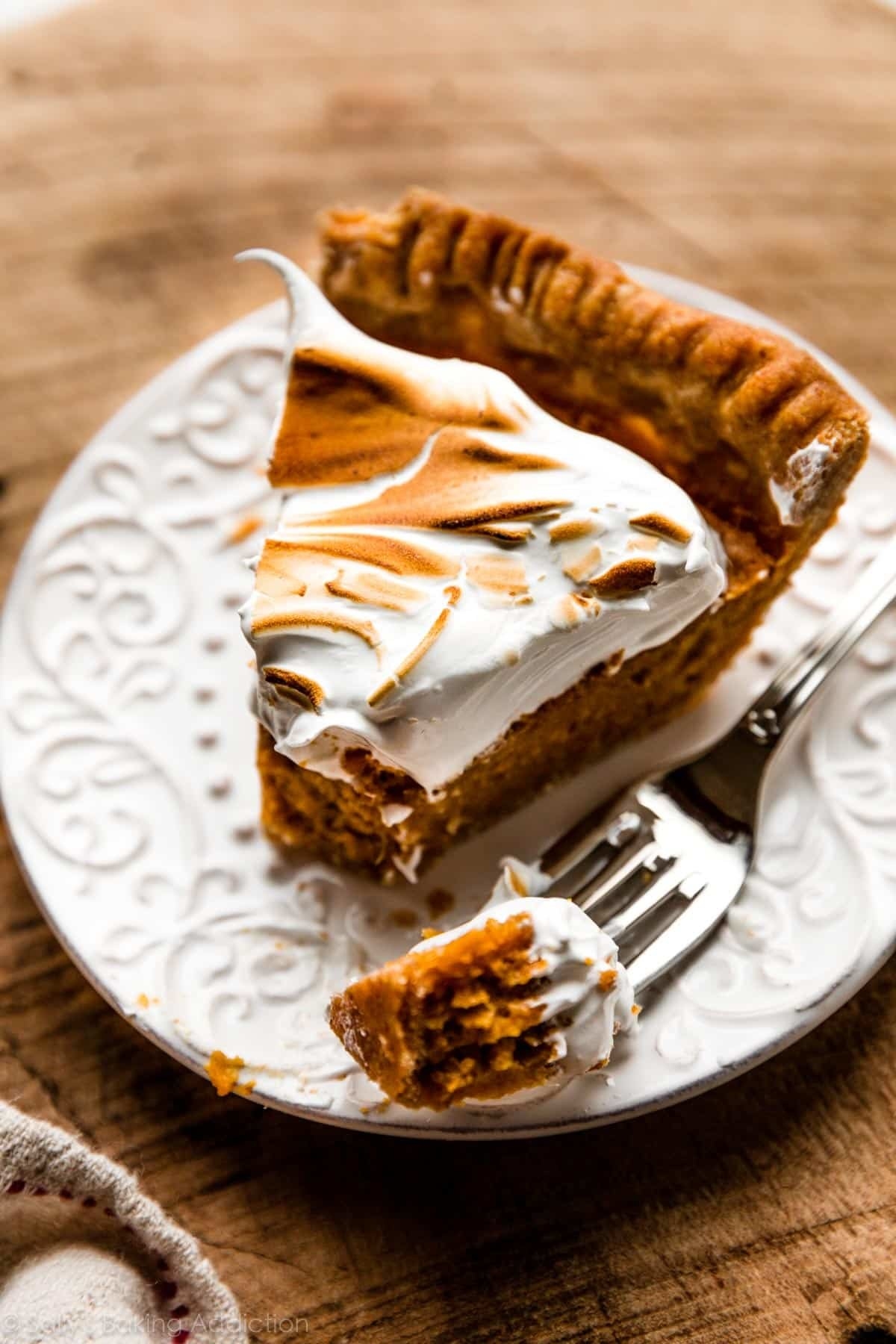 A slice of sweet potato pie with whipped cream