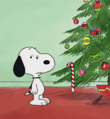Snoopy dancing by a Christmas tree