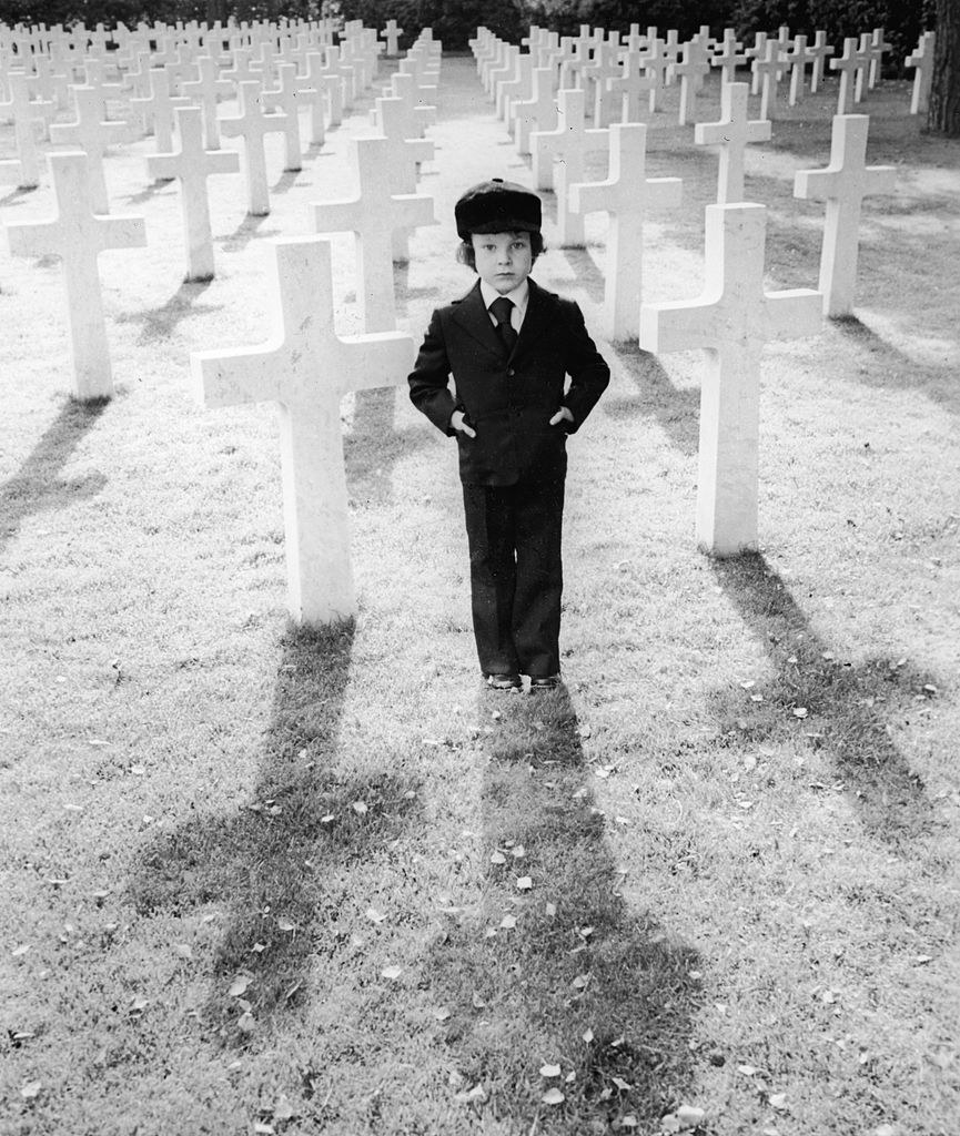 boy standing in a cemetery