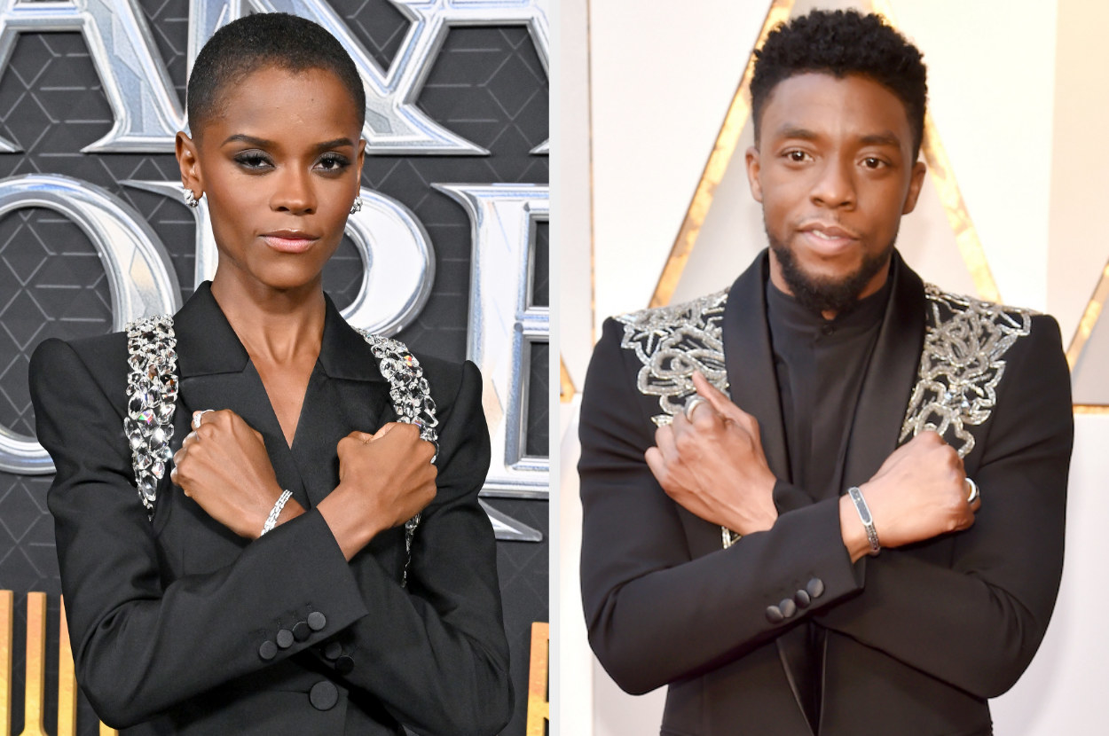 Letitia on the left wearing a pantsuit bedazzled on both shoulders similar to Chadwick&#x27;s suit on the right. They are both doing the Wakandan salute