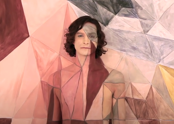 Gotye with a geometrical image superimposed over his face and bare torso