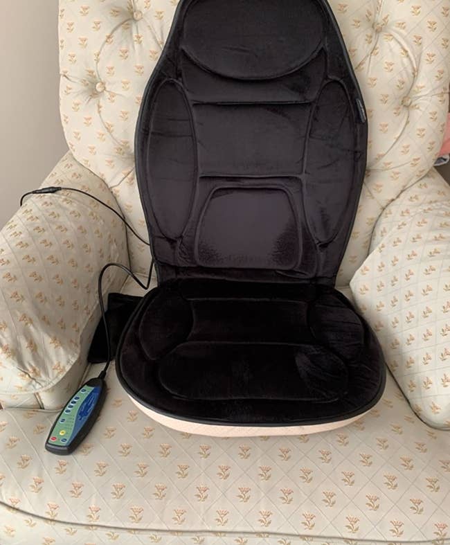 The massage seat cushion on a chair with its remote control
