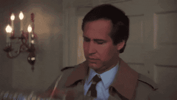 gif of father from christmas vacation shaking a wrapped present