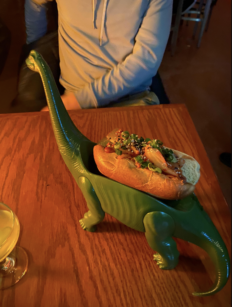 A glass dinosaur holding a bread loaf