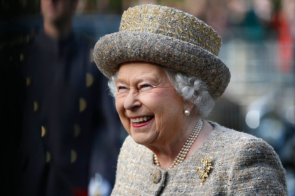 The Queen wearing a hat and smiling