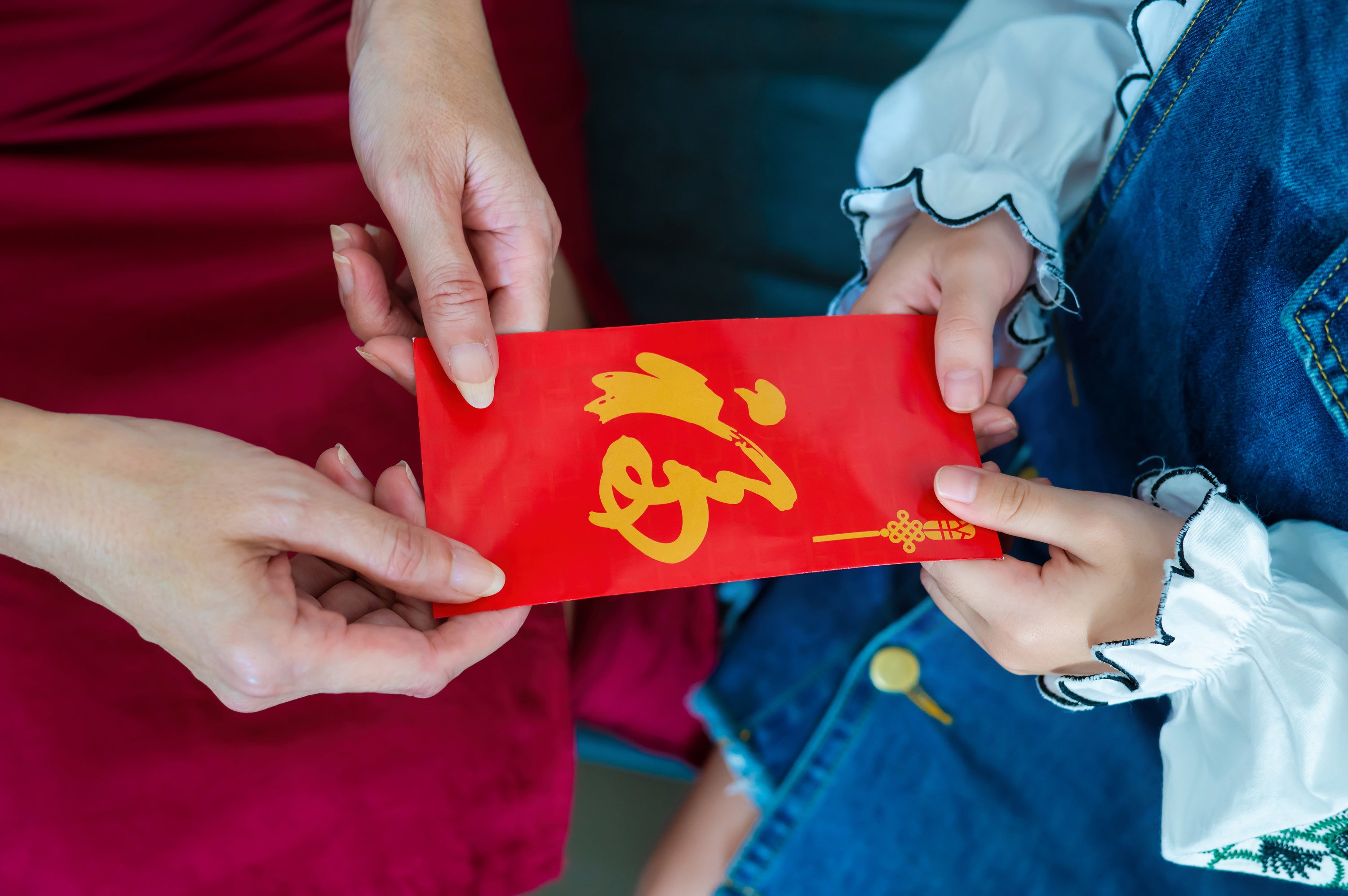 young girl accepts red envelope for Lunar New Year