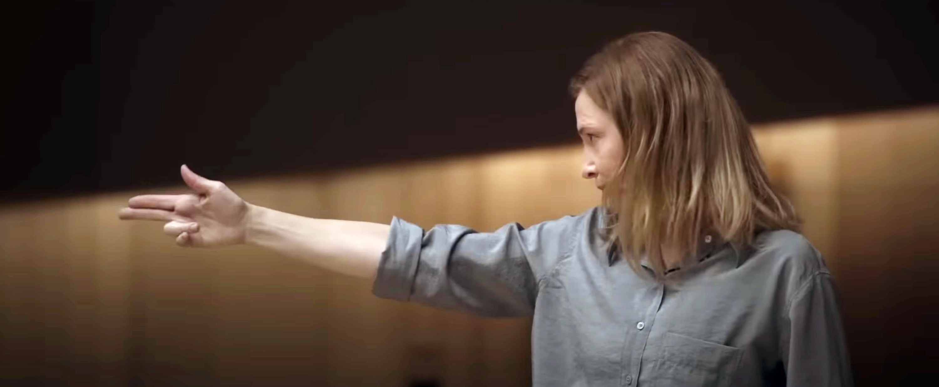 Lydia conducting, her arm pointed out with two fingers