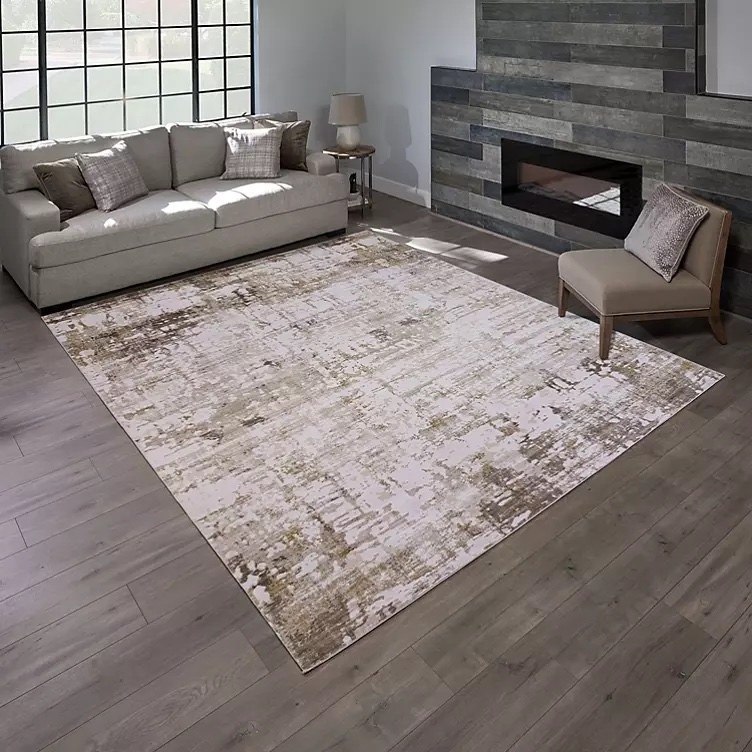 A grey and white rug on a wooden floor