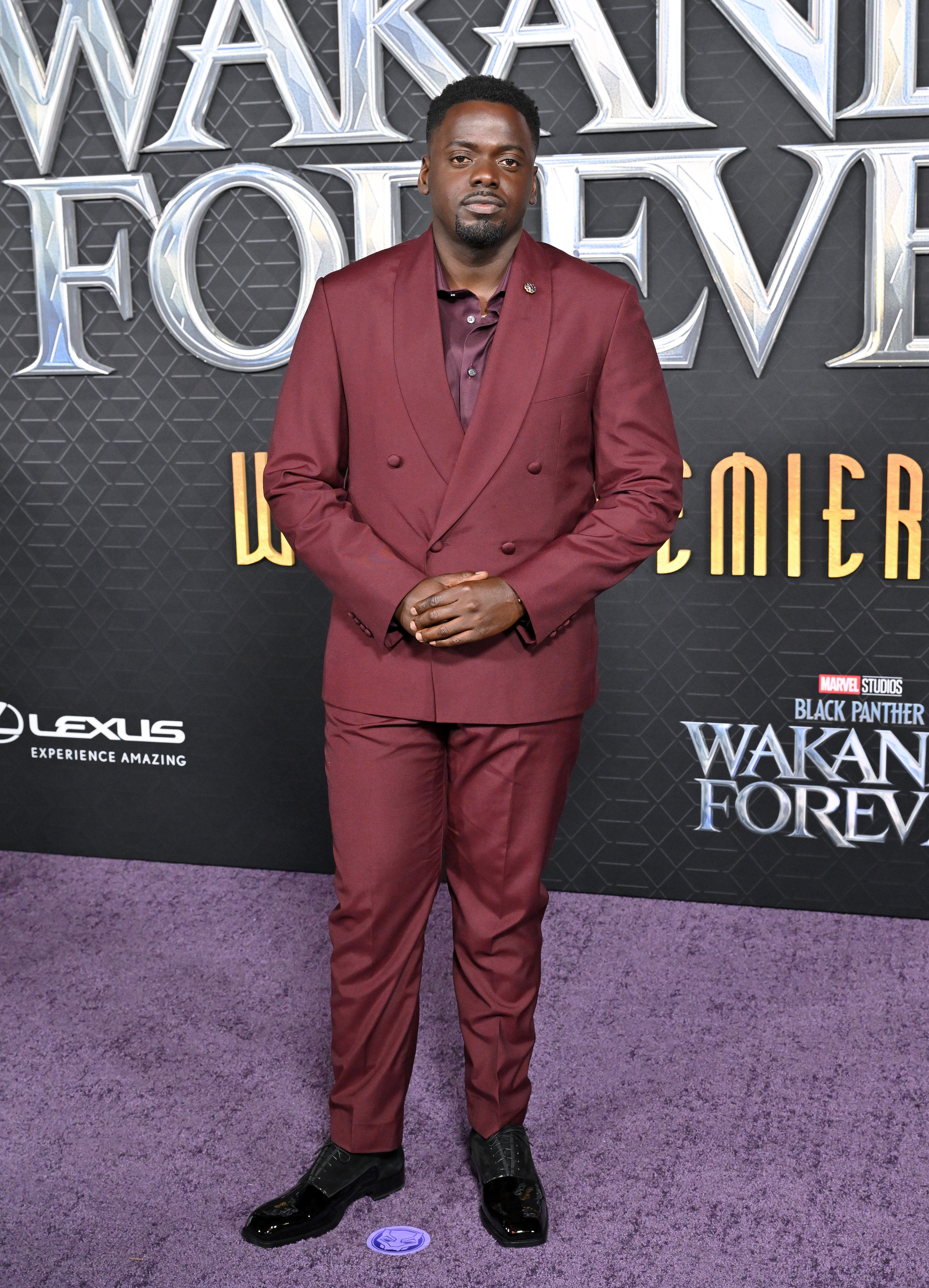 Daniel poses on the purple carpet in a monochrome suit