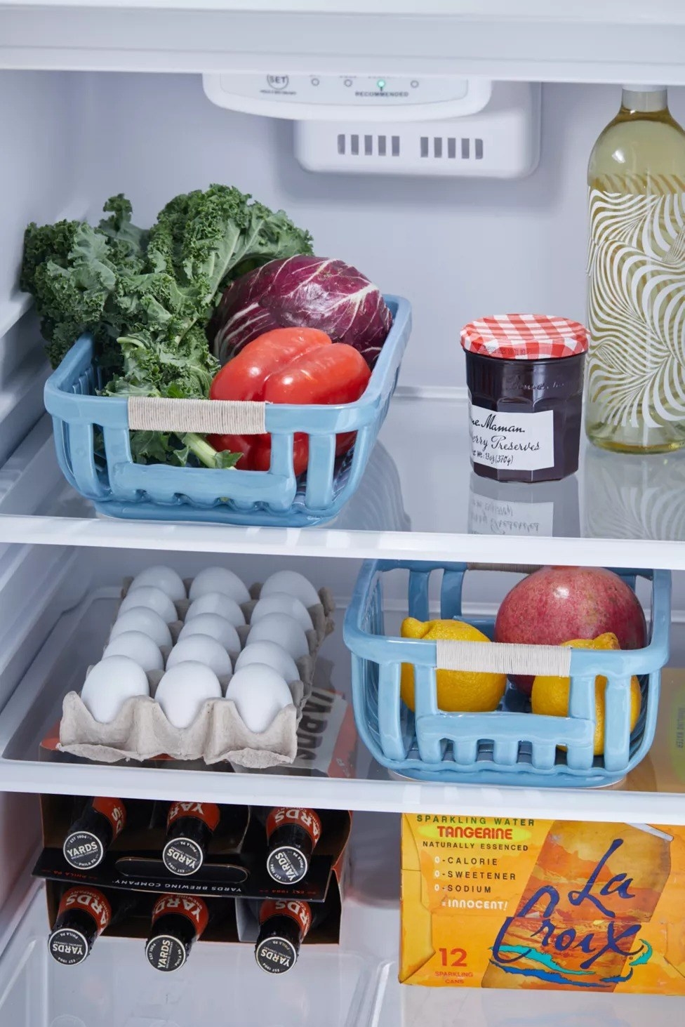 Two blue ceramic baskets are shown in a fridge