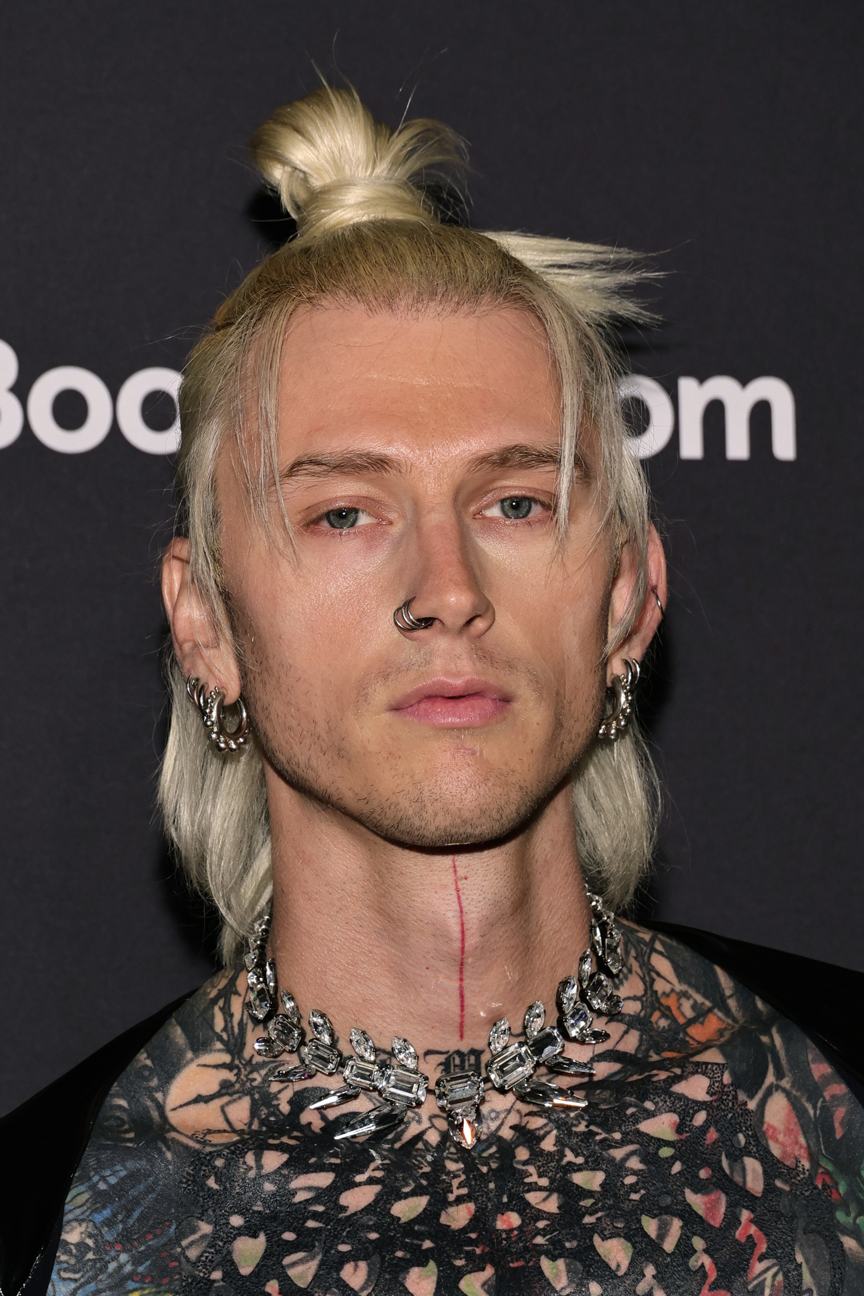 Close-up of MGK with a mullet-type bun hairstyle
