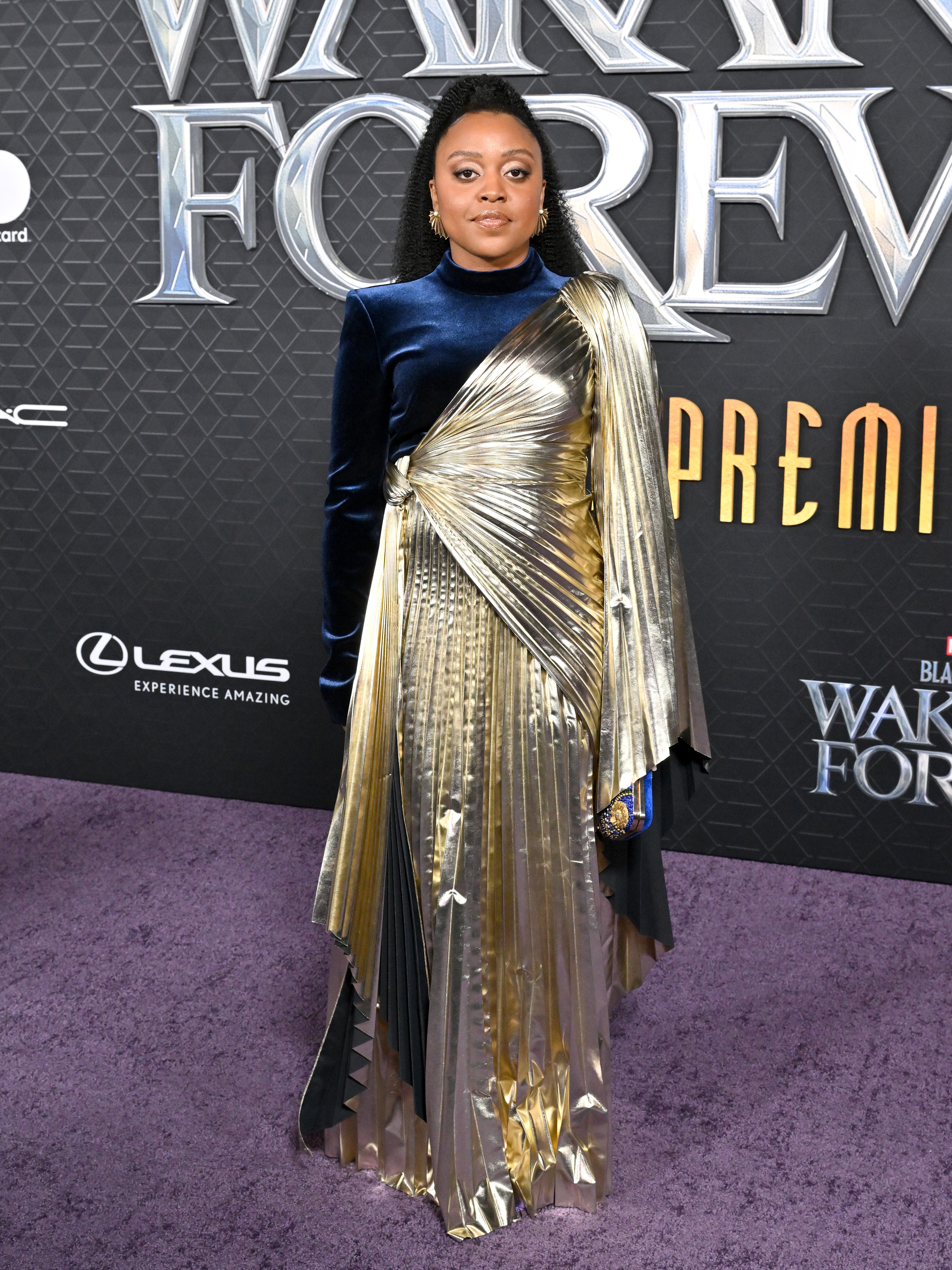Quinta wore a long-sleeved gown with a pleated metallic overlay on one side