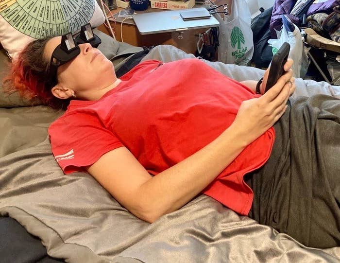 a reviewer wearing the spectacles while laying down and using their phone