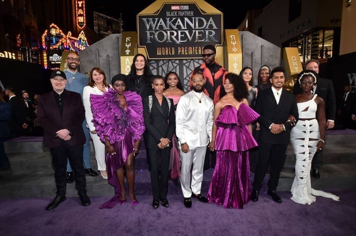 The cast and crew pose for a group photo on the red carpet