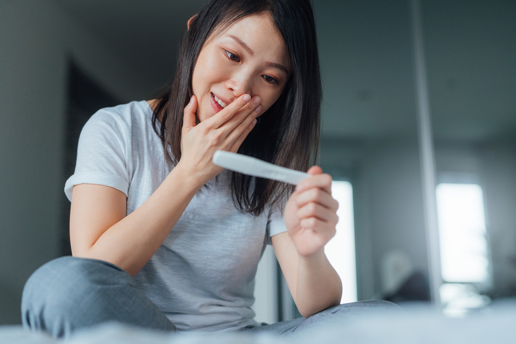 woman looking at a pregnancy test
