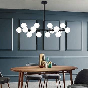 the black orb light fixture over a dining table