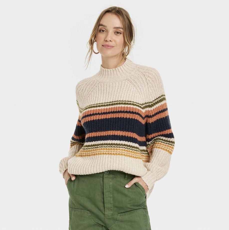 The model wears the light cream option with dark earth-tone stripes