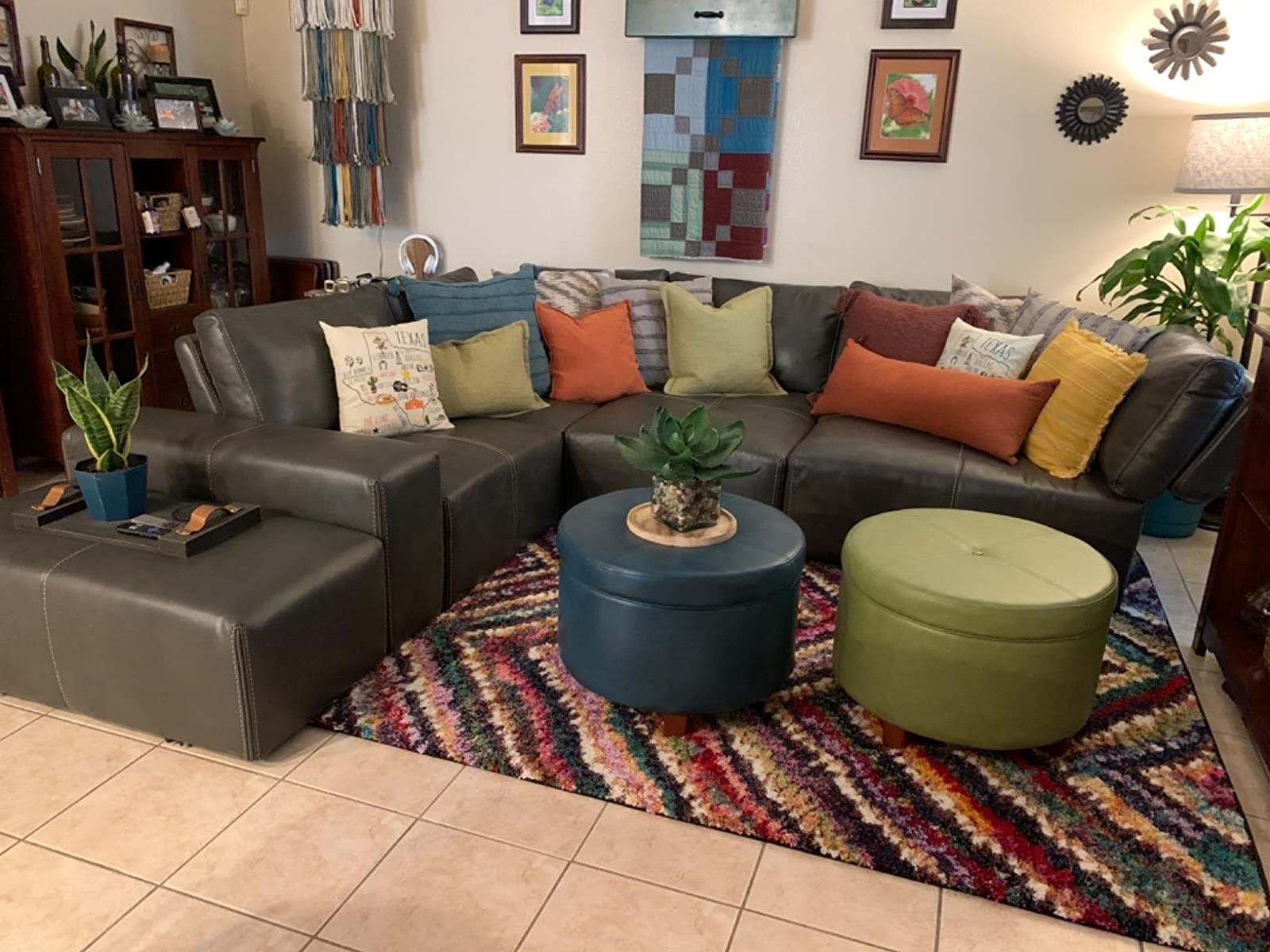 the teal ottoman in front of sectional couch on rug