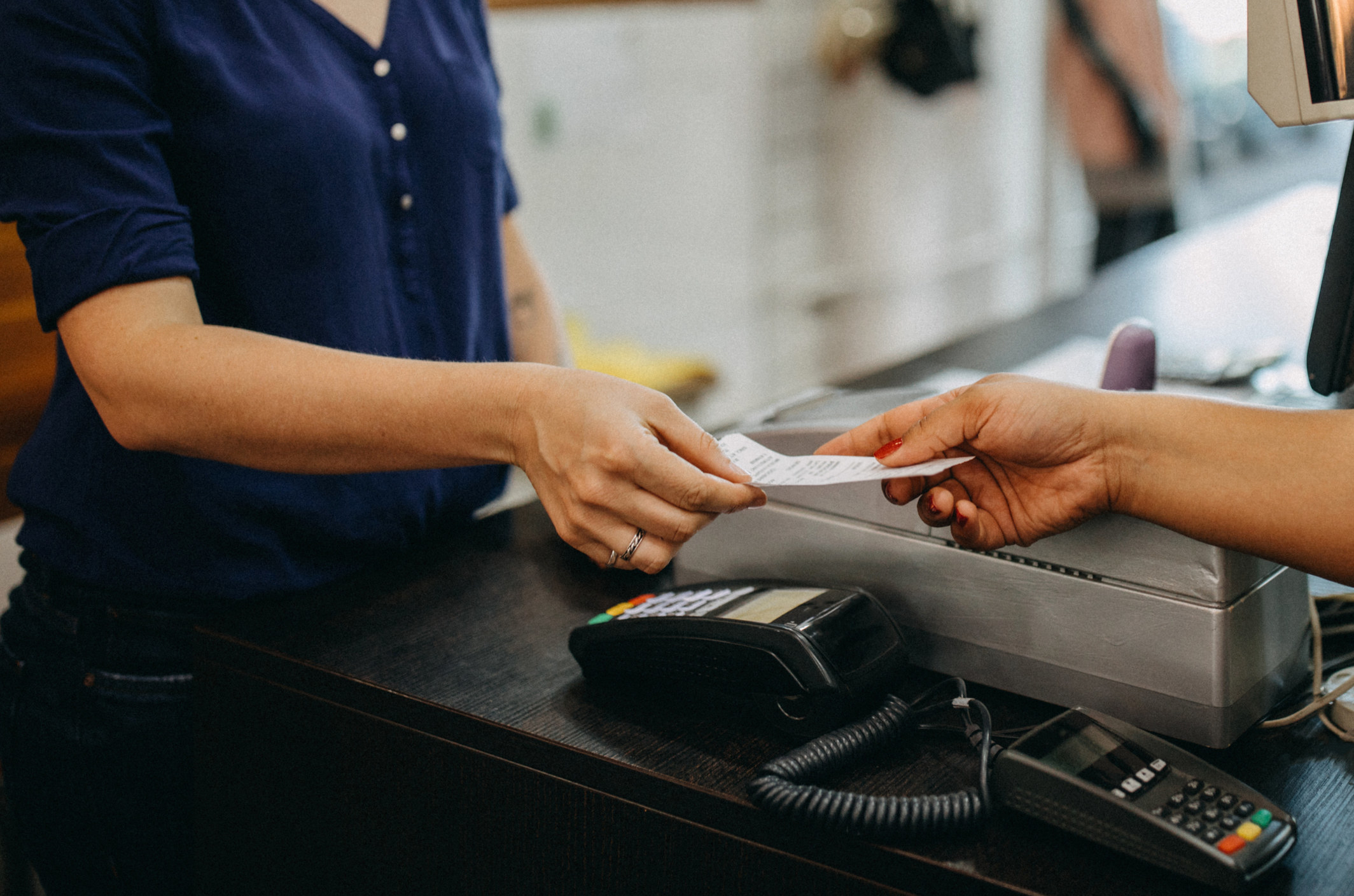A cashier handing someone their receipt