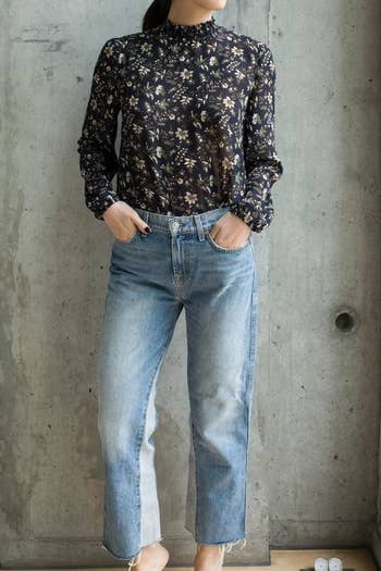 reviewer wearing the floral top in dark blue, tucked into denim jeans
