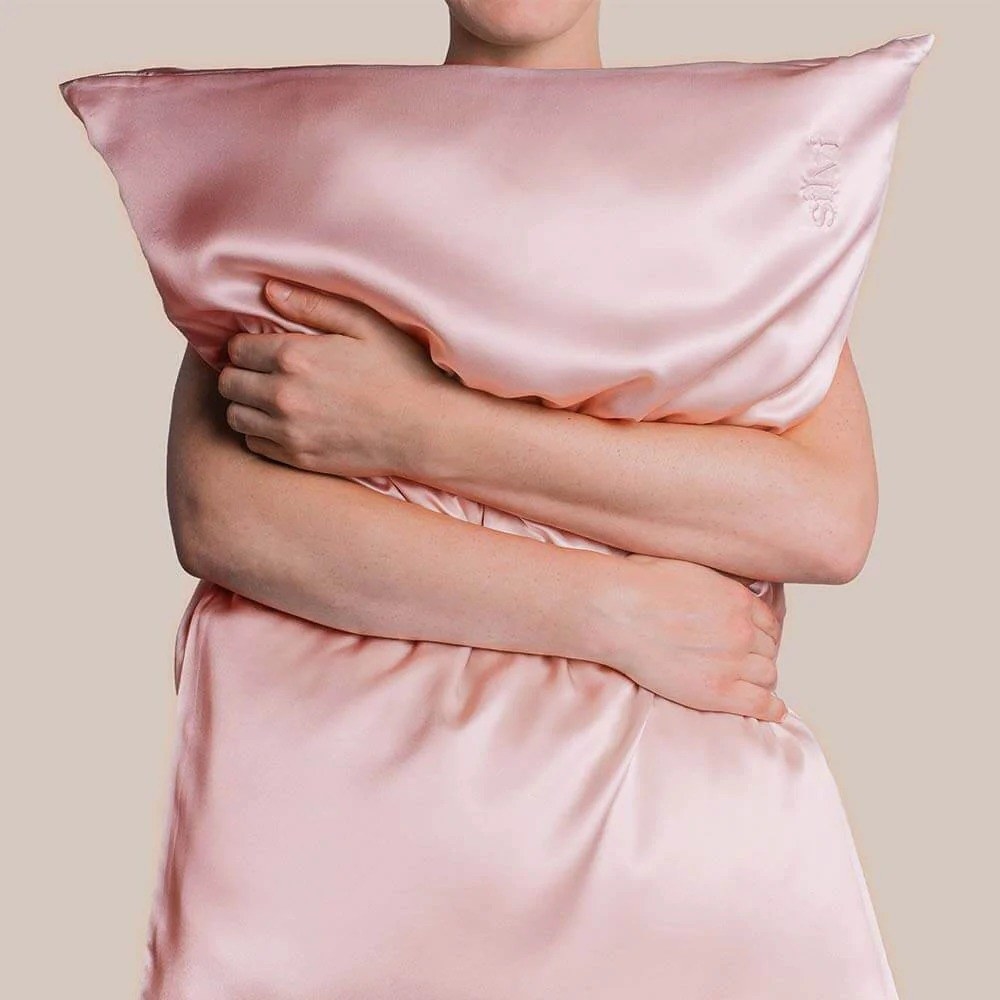 model holding a pillow in a pink pillowcase
