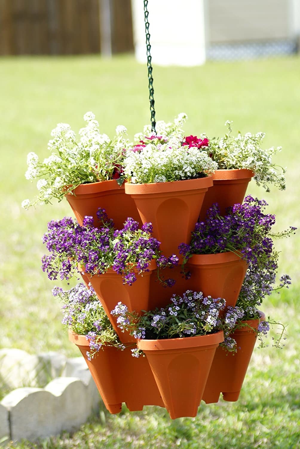 a stackable planter pot hung outdoors and filled with flowers