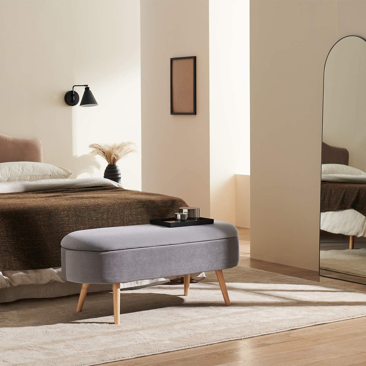 oval mid century modern storage bench at foot of a bed